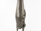 a silver vase with a bird on it on a stand