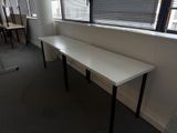 une longue table blanche dans une pièce dotée d'une fenêtre