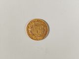a close up of a gold coin on a white surface