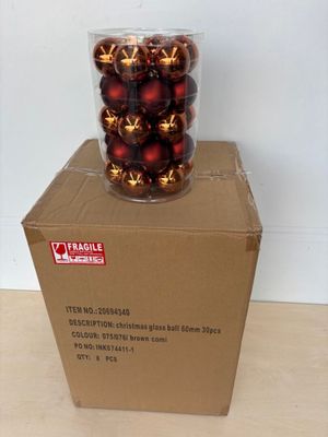 une boîte remplie de décorations rouges et dorées posée sur une table