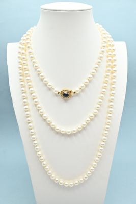 a close up of a necklace with pearls on a mannequin