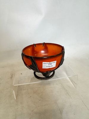 an orange bowl on a stand with a label on it