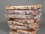 plusieurs morceaux de bois empilés les uns sur les autres, sur lesquels figurent des inscriptions