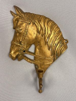 gold colored horse head hook on a white background