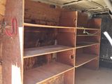 a wooden shelf with a pair of scissors on it in a garage