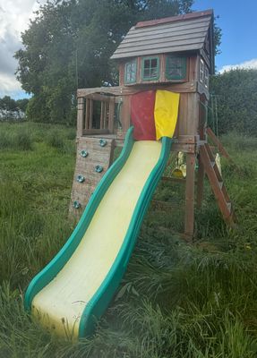 une structure de jeux en bois avec un toboggan au milieu