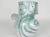 a green and white vase with a spiral design on it