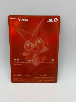 La carte Pokémon est posée sur une surface blanche avec un fond rouge.