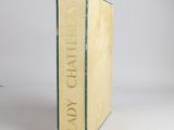 an old book sitting on top of a white table next to a white wall