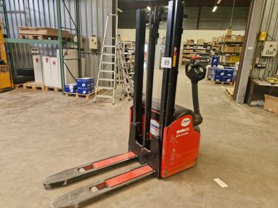 un chariot élévateur dans un entrepôt, avec des cartons et des palettes en arrière-plan