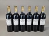 six bottles of wine are lined up on a table