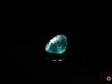 a close up of a green diamond on a black surface