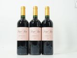trois bouteilles de vin posées sur une table blanche