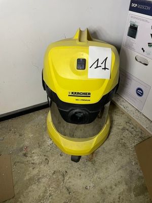 un aspirateur jaune posé par terre à côté d'un carton