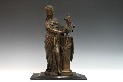 statue en bronze d'une femme tenant un oiseau sur un piédestal