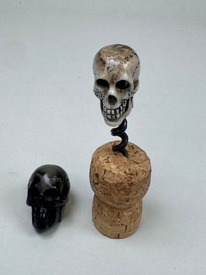 a bottle stopper that has a skull on top of it