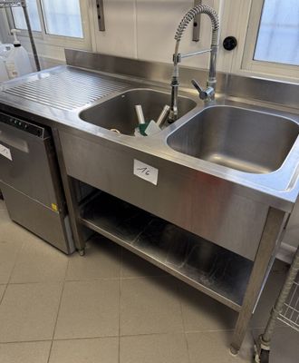 un évier en acier inoxydable au milieu d'une cuisine