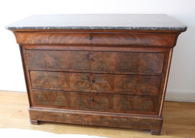 a wooden dresser with marble top on a hard wood floor