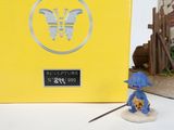 a figurine of a man with a blue hat and a sword