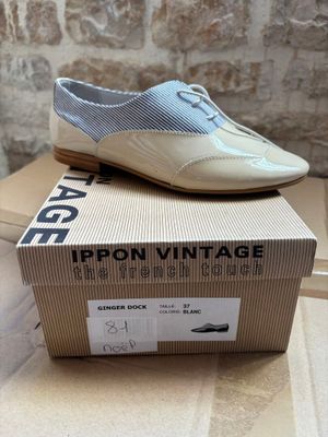 beige and blue shoes on top of a cardboard box on a table