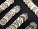 some silver coins are arranged in a row on a black surface