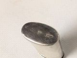 a close up of a silver object on a white surface