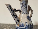 a blue and white vase with a handle on a table