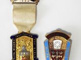 On voit deux médailles sur un fond blanc : l'une est une médaille et l'autre est une médaille.