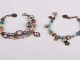 two bracelets with beads and charms on a white surface