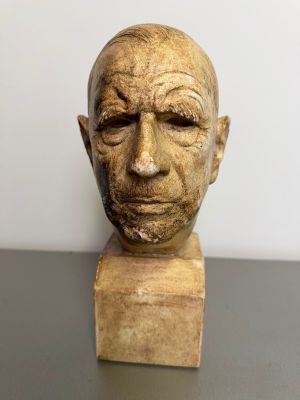 a close up of a sculpture of a man ' s head on a table