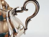 a silver pitcher that is sitting on a table