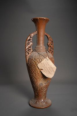 un vase marron muni d'une étiquette, posé sur une table