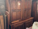 un canapé et un fauteuil dans une pièce où se trouve une armoire en bois
