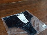 un sac en plastique posé par terre à côté d'un pantalon noir