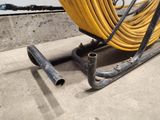 a yellow hose sitting on a cart in a garage