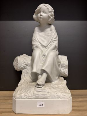 une statue blanche représentant une jeune fille assise sur un rocher