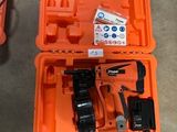 une boîte à outils orange contenant des outils, posée par terre