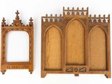 two pieces of wood with carvings and a picture frame on a white surface