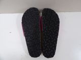 pair of black shoes with pink soles sitting on a white surface