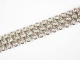 gros plan d'un bracelet en argent sur une surface blanche