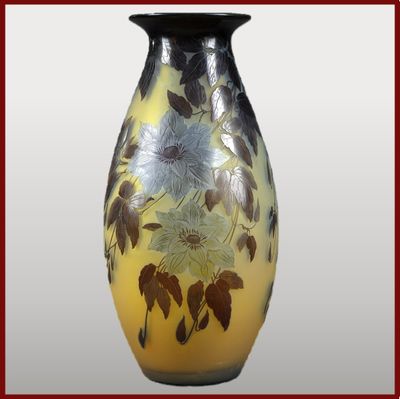 un vase jaune orné de fleurs noires et blanches