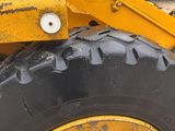 a yellow tractor with a big tire on the street