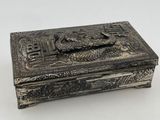 a silver box with a bird on it sitting on top of a table