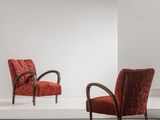 two red chairs sitting on a white platform in a white room