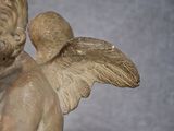 a statue of an angel holding a bird in his hands