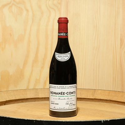 a bottle of wine sitting on top of a barrel