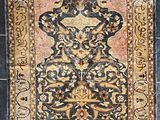 un vieux tapis orné d'un motif, posé sur un sol carrelé