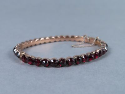 un gros plan d'un bracelet en grenats rouges posé sur une table