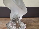a frosted glass bust of a man on a table