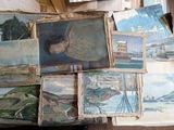 une pile de tableaux posée sur une table dans une pièce